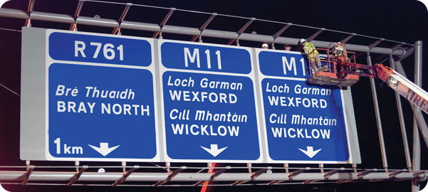 Image of a Worker Erecting an Overhead Sign on a Dual Carriageway propped up by a Crane